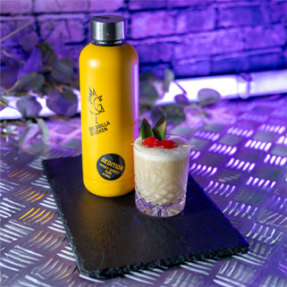 Banana and Honey Rum Daiquiri cocktail next to a bottle of Sedition honey spiced Rum